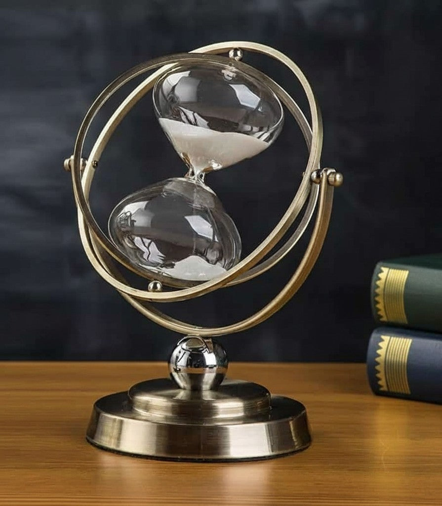 Antique metal globe-style hourglass sand timer displayed on a desk