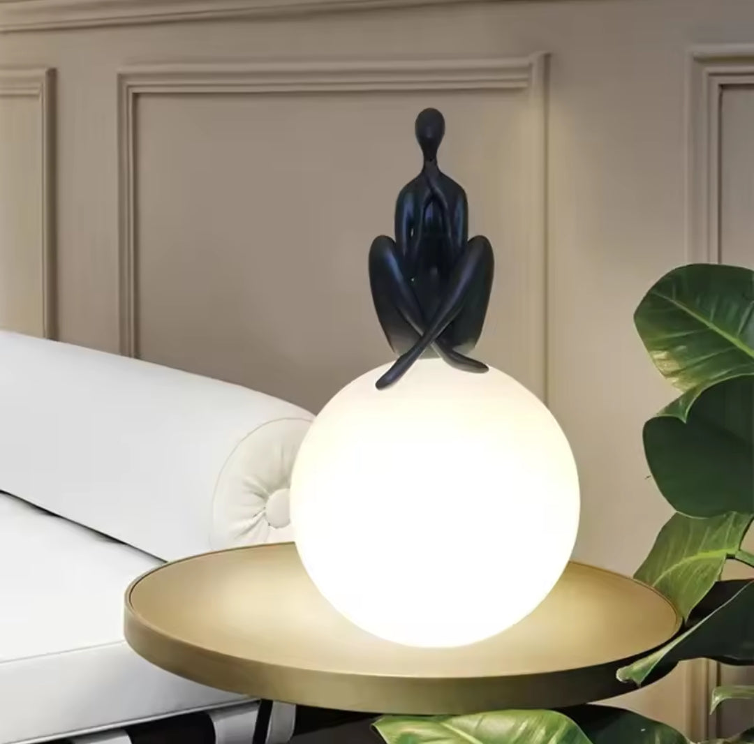 Abstract figure sitting on globe lamp modern art table light for home or office décor