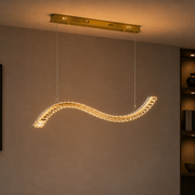 Gold wave crystal LED pendant light with tri-colour 18W lighting, curved chandelier design, and clear crystal accents for dining rooms, living rooms, hotels, reception areas, and modern interiors WH 2608-GO-TC - Gemelli Collection
