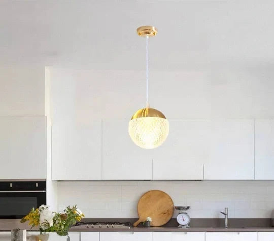 Dawood Lifestyle & Gadgets kes gold crystal globe pendant light featuring a textured clear glass sphere, luxury gold metal cap, and elegant ceiling-mounted design for modern and contemporary interiors.