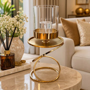 Gold candle holder with clear glass hurricane shade and sculptural circular base, available in Nairobi, Kenya