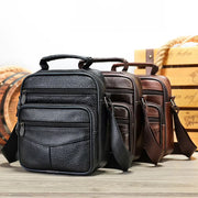 Unisex leather crossbody bag with multiple zipped compartments in black and brown