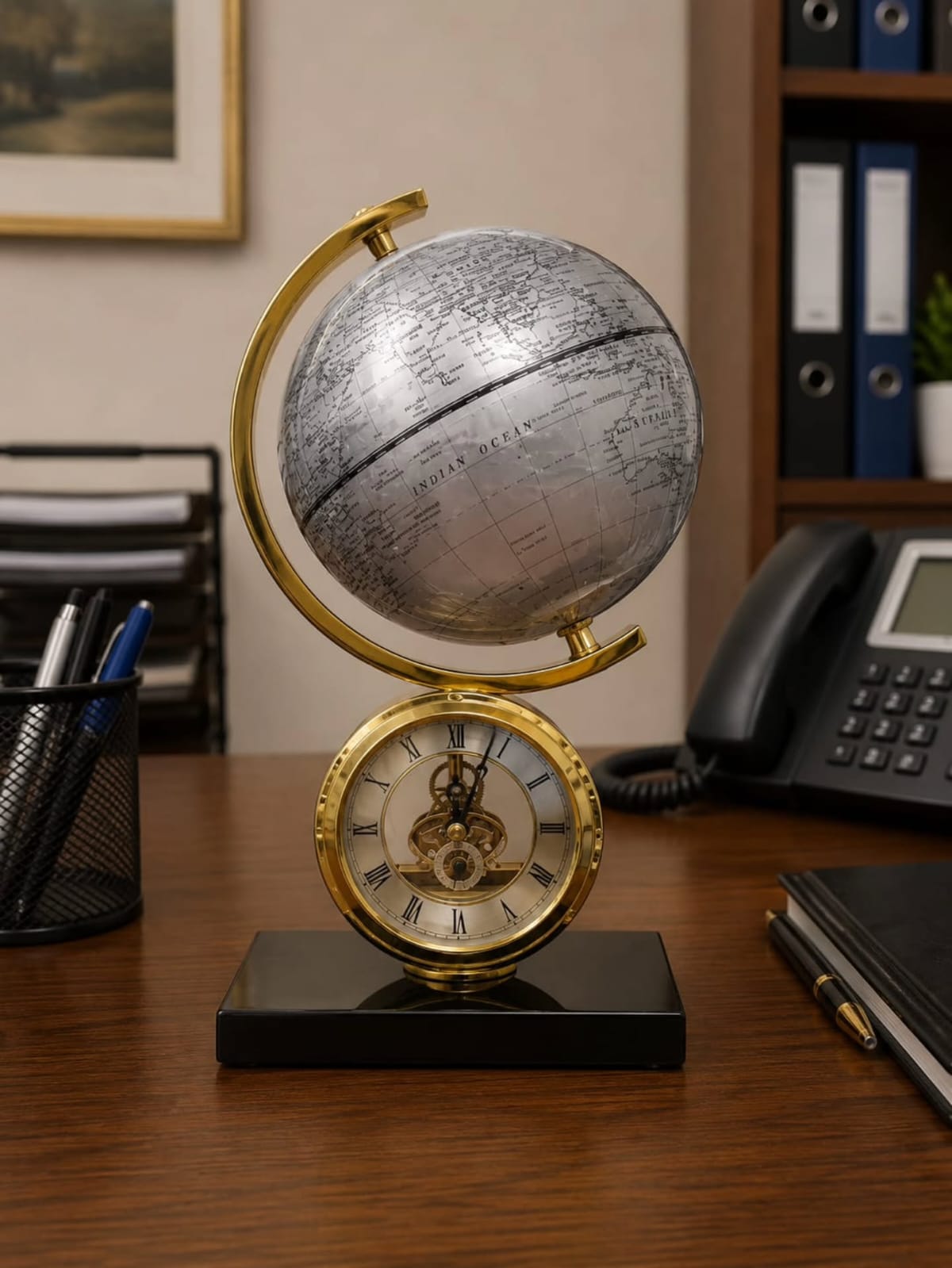 Dawood Lifestyle & Gadgets kes Atlasphere table clock featuring a rotating silver world globe, gold skeleton clock with Roman numerals, and black marble base for executive office décor.