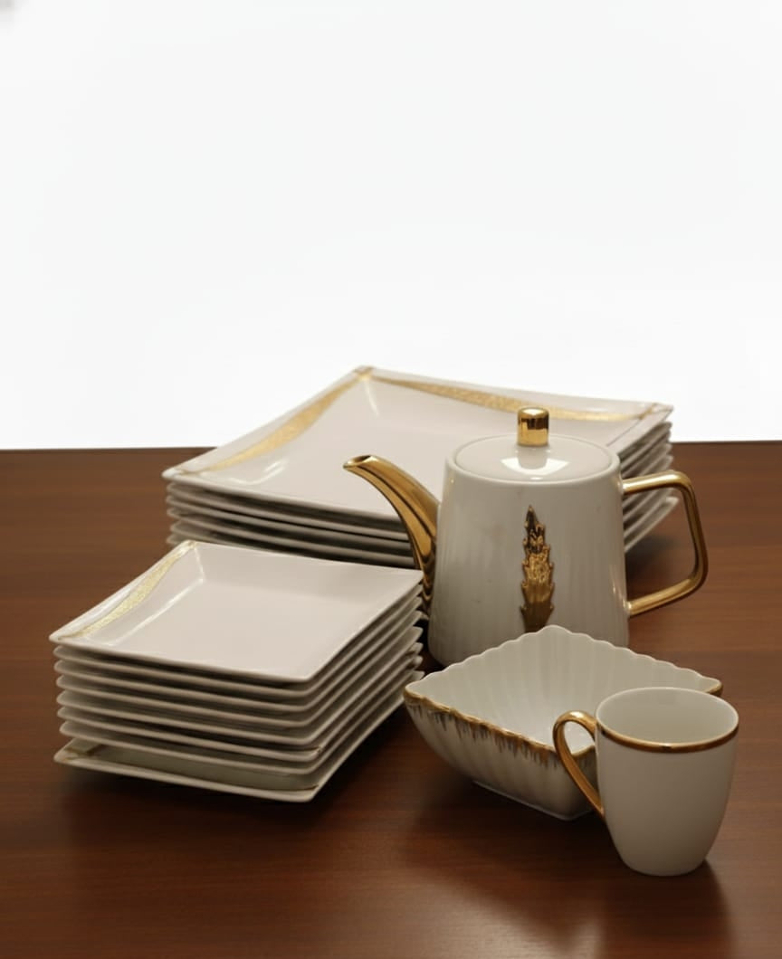 25-pieces porcelain dinner set with gold line accents, including cups, plates, bowls, and a gold leaf kettle