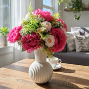Artificial flower arrangement placed in a plastic vase.