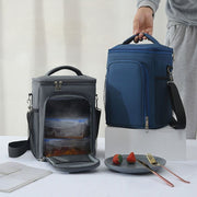 Insulated two-compartment lunch bag with crossbody strap.