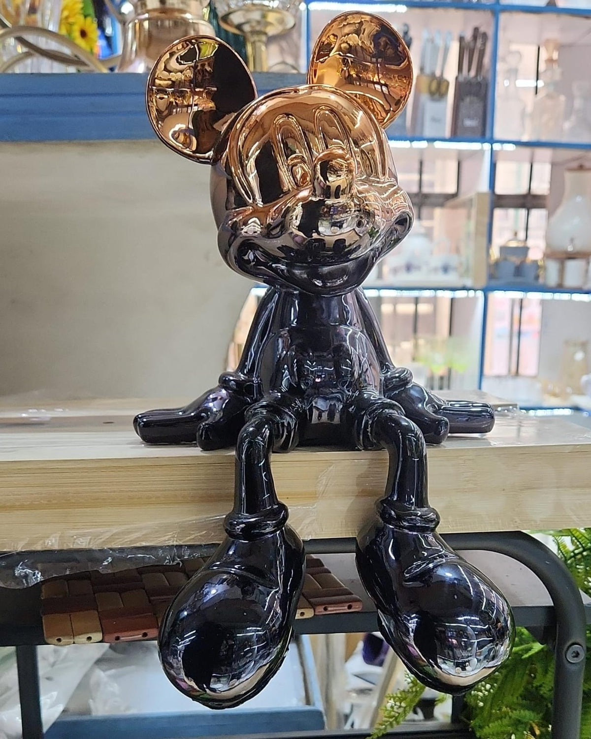Dawood Lifestyle & Gadgets kes chrome black sitting mouse character statue with metallic gold ears, reflective finish, and dangling legs for modern luxury home and office décor.