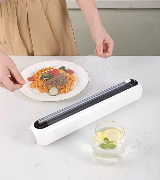 Plastic wrap cutter and cling film dispenser with included cling film roll