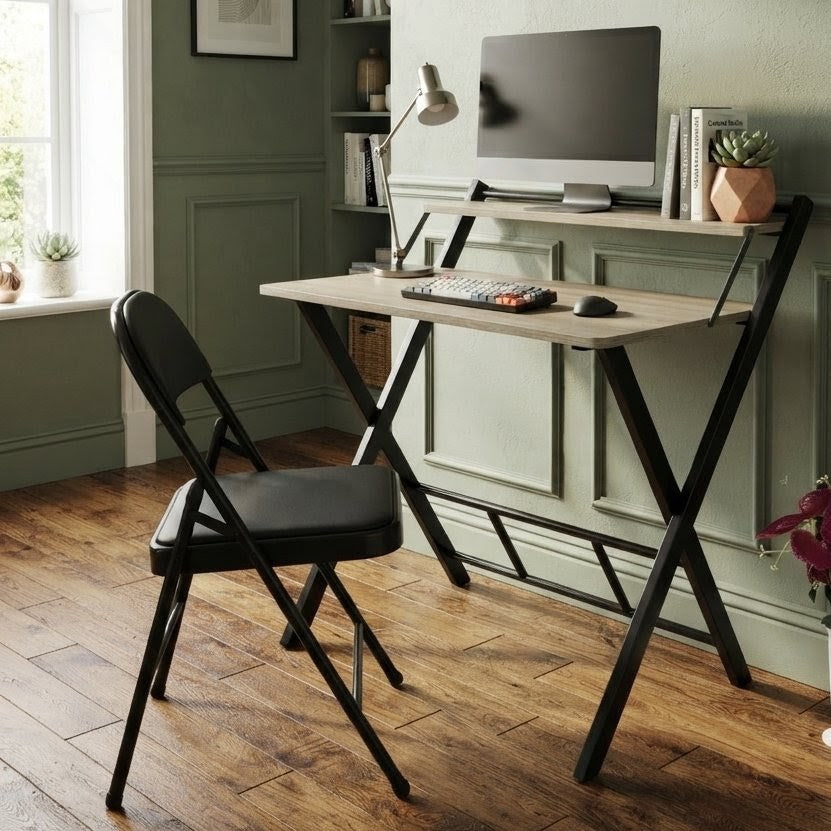 Foldable computer desk with a black metal frame, wood finish desktop, and integrated upper storage shelf for home office and study use.