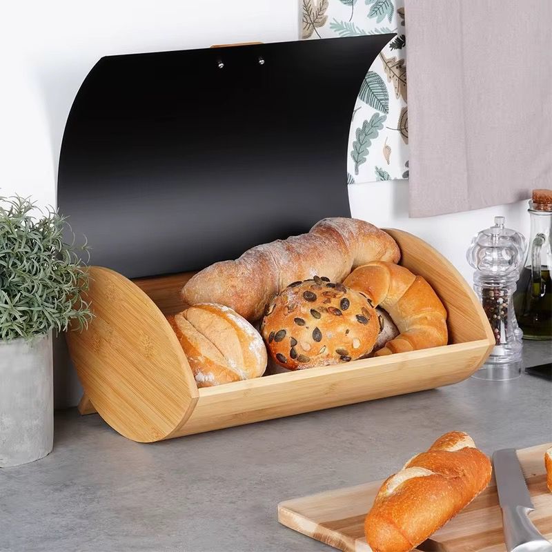 Bamboo bread bin with metallic cover for storing bread, buns, and pastries on the kitchen countertop
