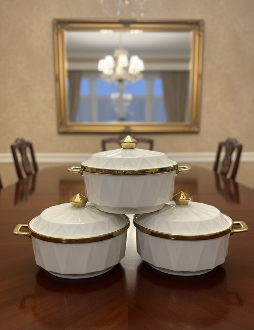 Three serving dishes with gold rims.