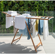 Foldable outdoor laundry drying rack made of wood and aluminium rods designed for space-saving clothes drying.