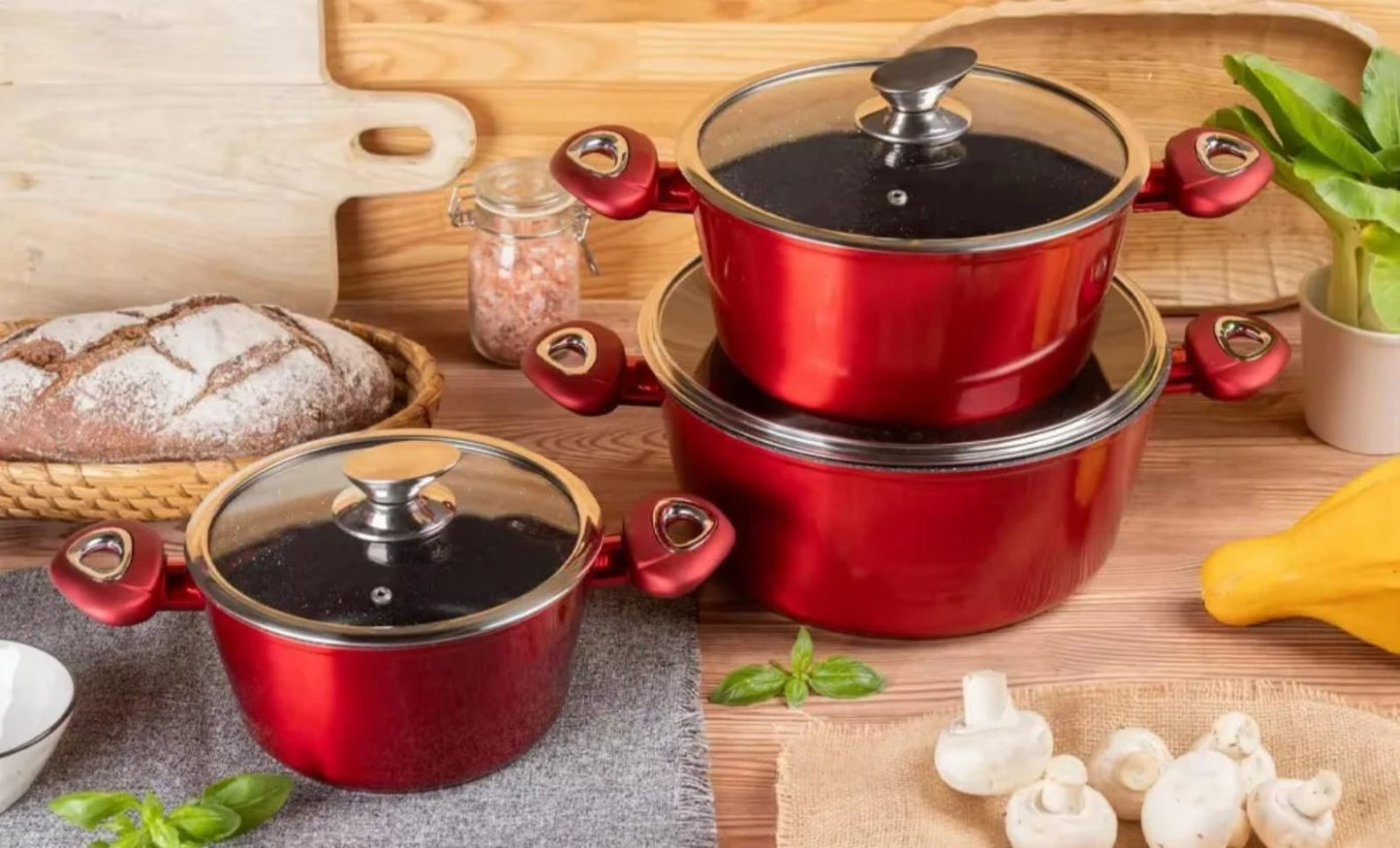 Red 3pcs non-stick casserole cookware set with glass lids on kitchen counter