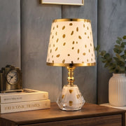 Golden Polka bedside table lamp with minimalist design and warm cozy glow for bedroom and living room décor.