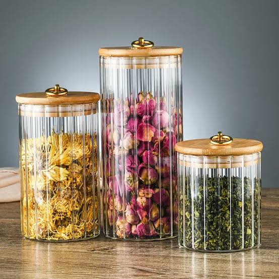 Glass storage containers with bamboo lids and golden pull rings in three sizes.