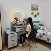 Gray vanity dressing table with oval LED mirror, ribbed drawers, open shelves, and detachable three-drawer storage cabinet.