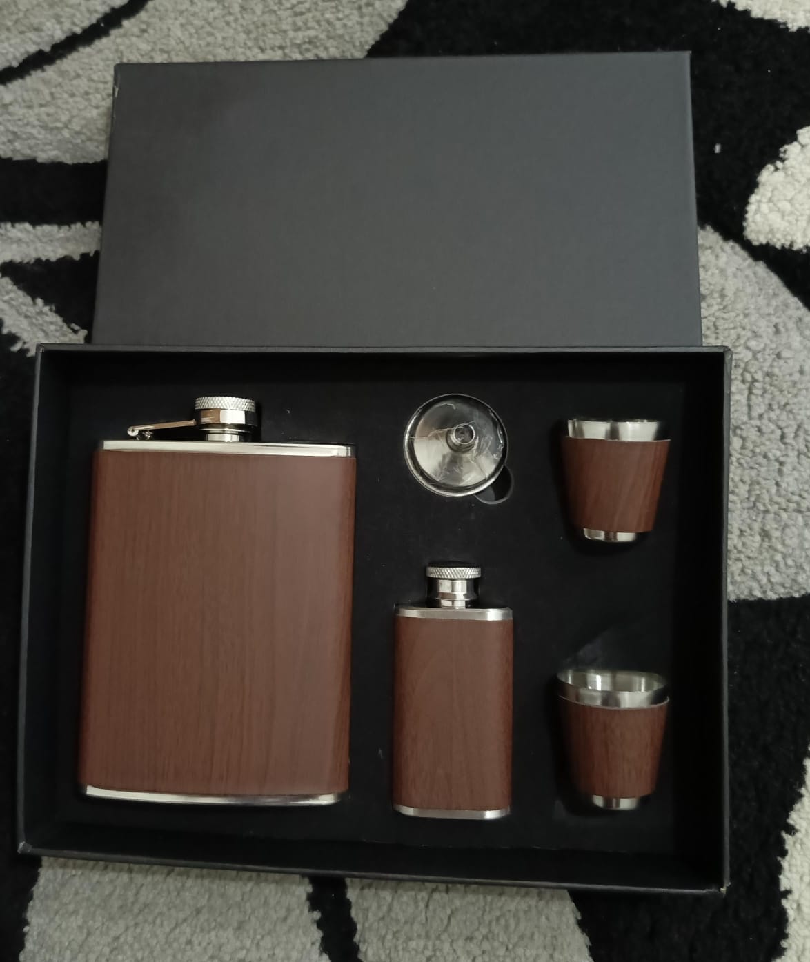Leather-covered whiskey flask gift set with two flasks, two shot glasses, and a filling funnel.