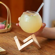 Round ball juice glass with a natural bamboo base, perfect for serving juice, water, cocktails, and other cold beverages.