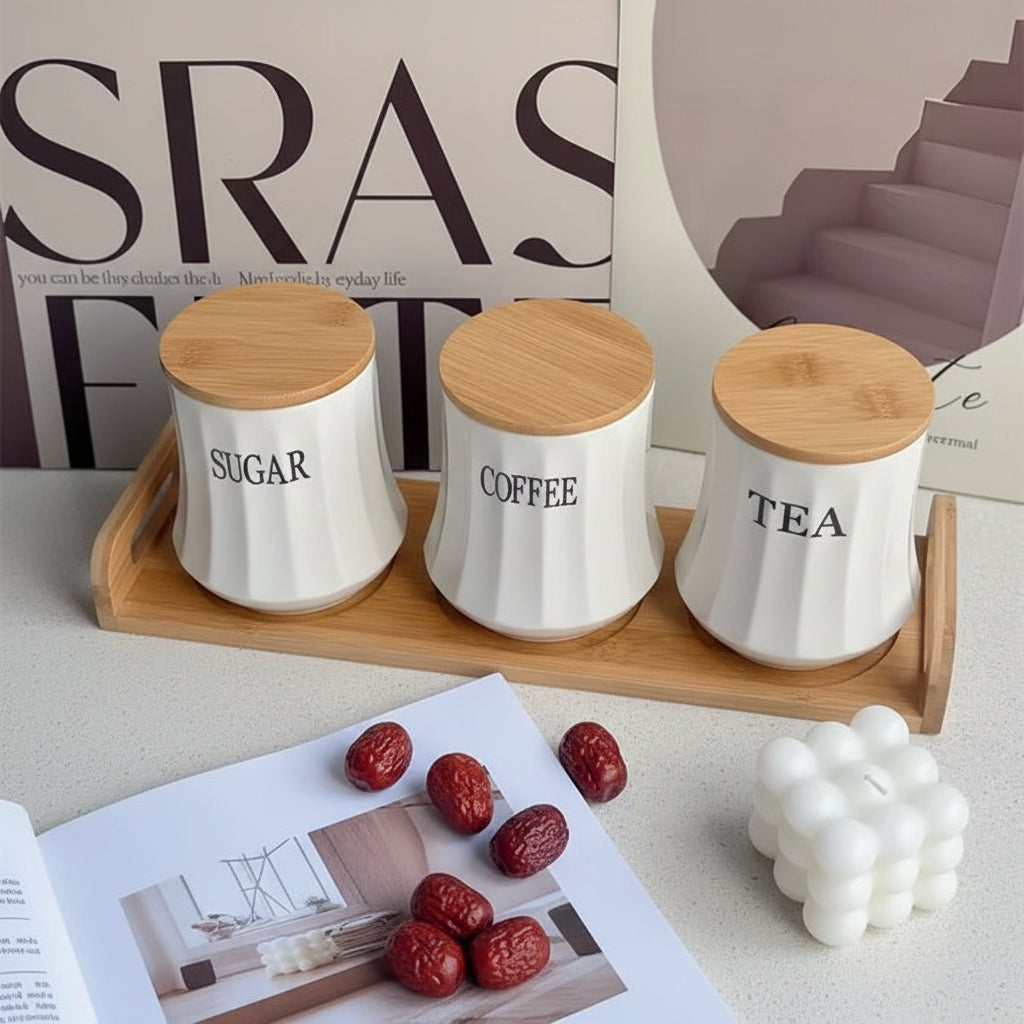 White ceramic tea, coffee, and sugar canister set with bamboo lids and matching bamboo stand for kitchen storage.