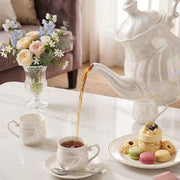Nine piece ceramic tea set with pearlescent finish including teapot, six cups, and round serving tray.