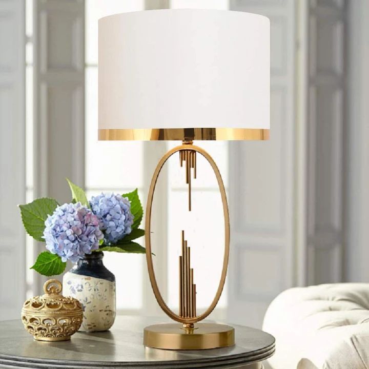 Luxury gold table lamp with fabric shade and metallic trim.