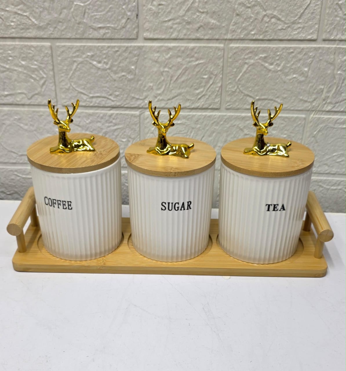Three ribbed ceramic tea, coffee, and sugar canisters with bamboo lids and matching bamboo tray.