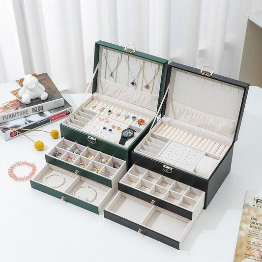 Multi layer jewelry storage box with embossed leather exterior and large capacity compartments in white, black, and green.