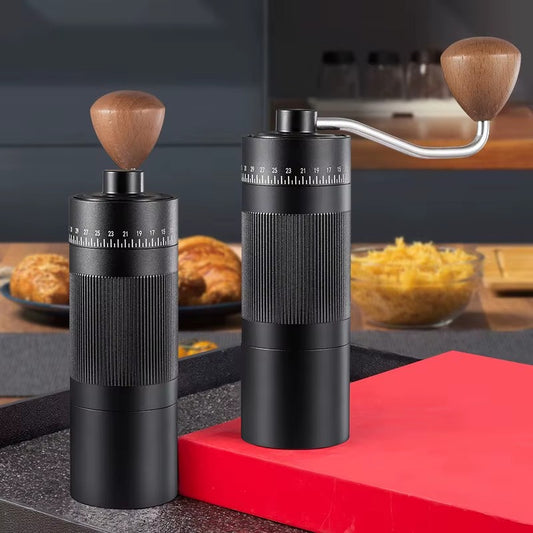 Handheld manual coffee grinder with stainless steel burr in black and silver.
