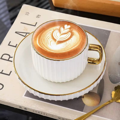 European style ceramic coffee and tea cup set with gold edge and matching saucers.
