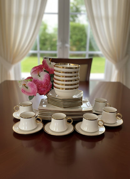 Gold 30-piece dinner set with plates, bowls, cups, and saucers arranged on a table.