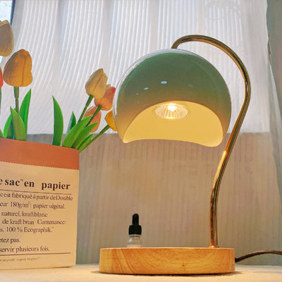 Electric candle warmer with a wooden base and metal frame for flameless fragrance and elegant home décor.