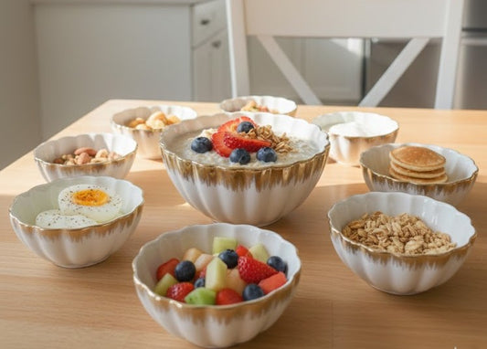 White ceramic shell bowls with gold rim detailing in assorted sizes