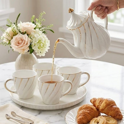 Nine piece white porcelain tea set with gold trim for elegant tea, coffee, and hot chocolate serving.