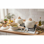 9 piece cream beige non stick cookware set with ceramic coating, four pots, four lids, one pan, and light wood style handles.