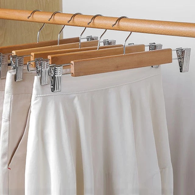 Set of five natural wooden hangers with adjustable clips and swivel hooks.