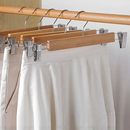 Set of five natural wooden hangers with adjustable clips and swivel hooks.