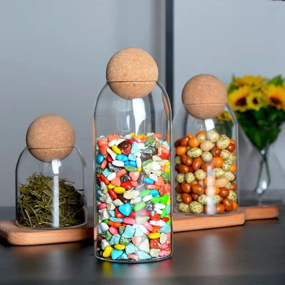 Set of three transparent storage jars with bamboo lids in different sizes.