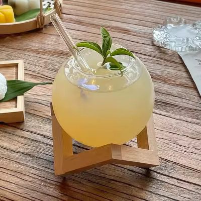 Round ball juice glass with bamboo base for stylish serving of juice, smoothies, and cold drinks