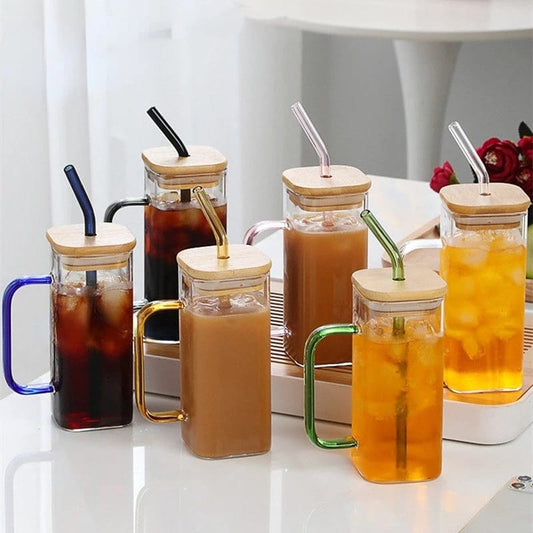 Transparent borosilicate glass drinking cup with clear handle and bamboo lid, 500ml capacity.