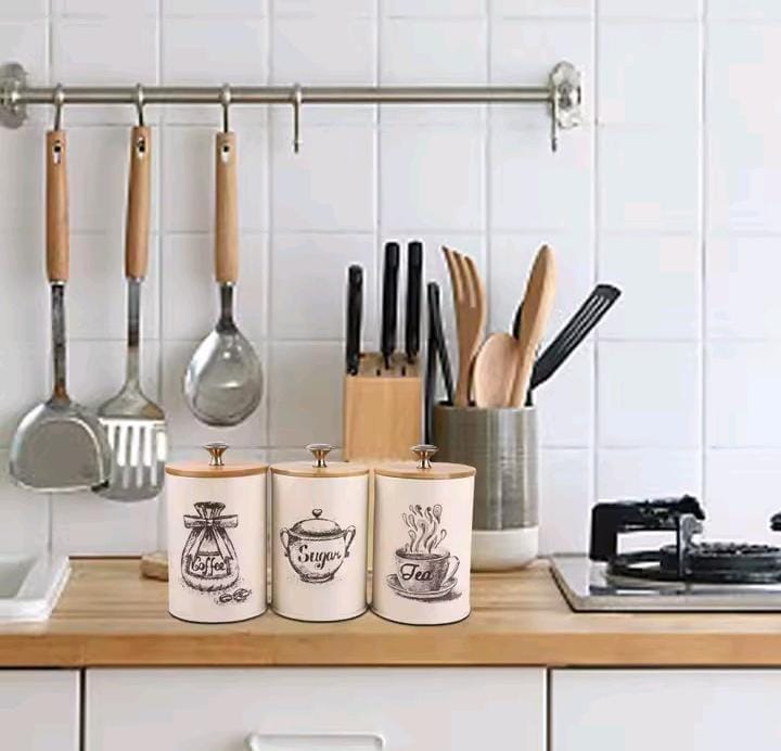 Set of cream white airtight metal canisters for sugar, tea, and coffee