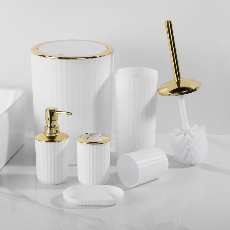 6-piece  round and square bathroom accessories set with gold and silver accents, including trash can, soap dispenser, soap dish, toilet brush with holder, toothbrush holder, and cup.