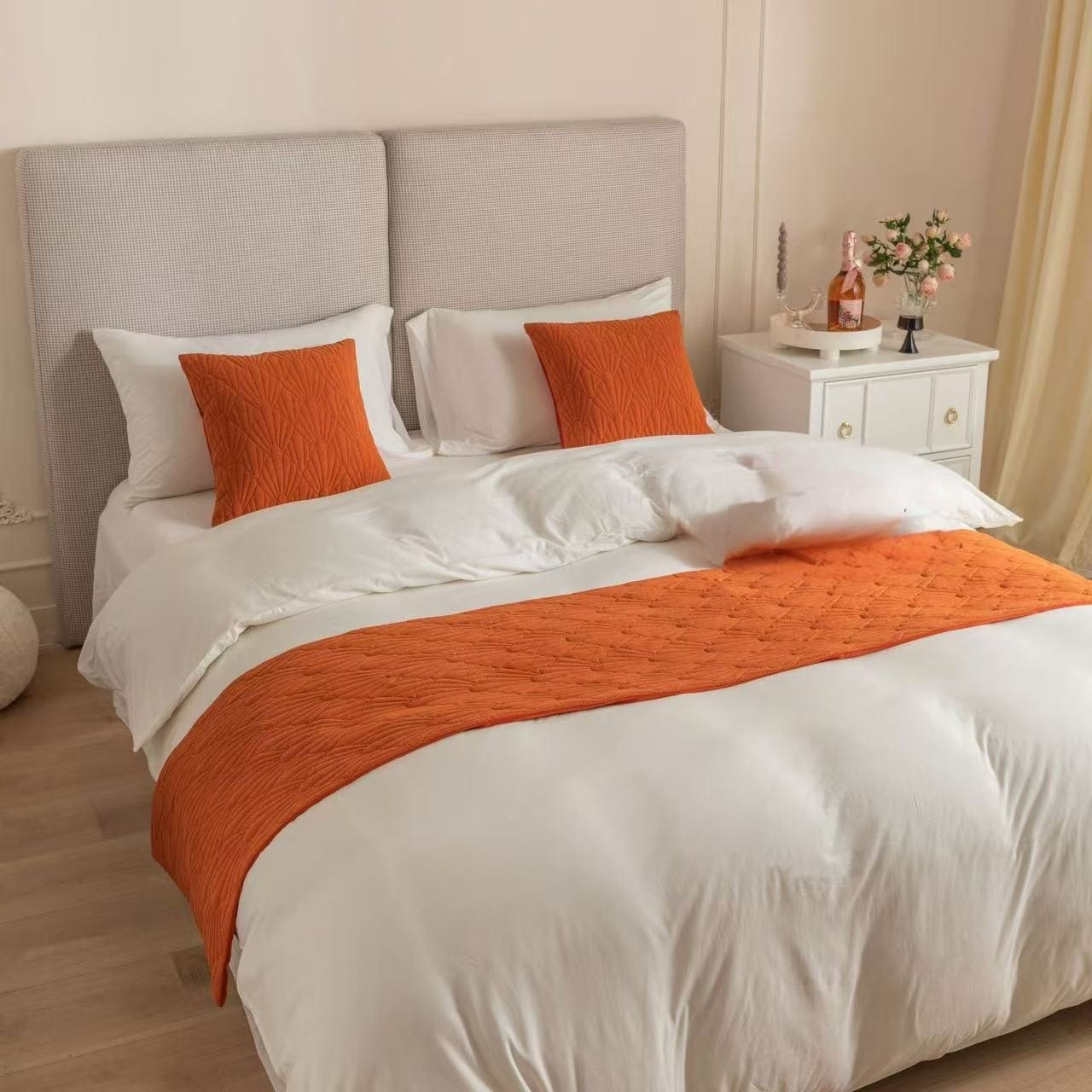 Decorative bedrunner set with matching cushion covers on a bed.