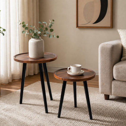 Twin round nesting coffee tables with dark wood look tops and black metal legs, modern space saving set.