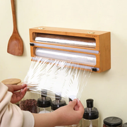 Wooden aluminum foil wrap dispenser with easy cutting design for organized kitchen storage and convenient food preparation.
