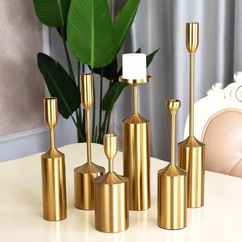 Gold metal candle holders in assorted sizes for elegant home décor, wedding centerpieces, and decorative table displays.