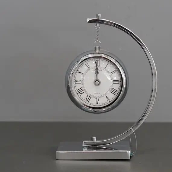 Dawood Lifestyle & Gadgets kes silver hanging tabletop quartz clock with polished chrome arch stand, Roman numeral dial, and modern executive desk design.
