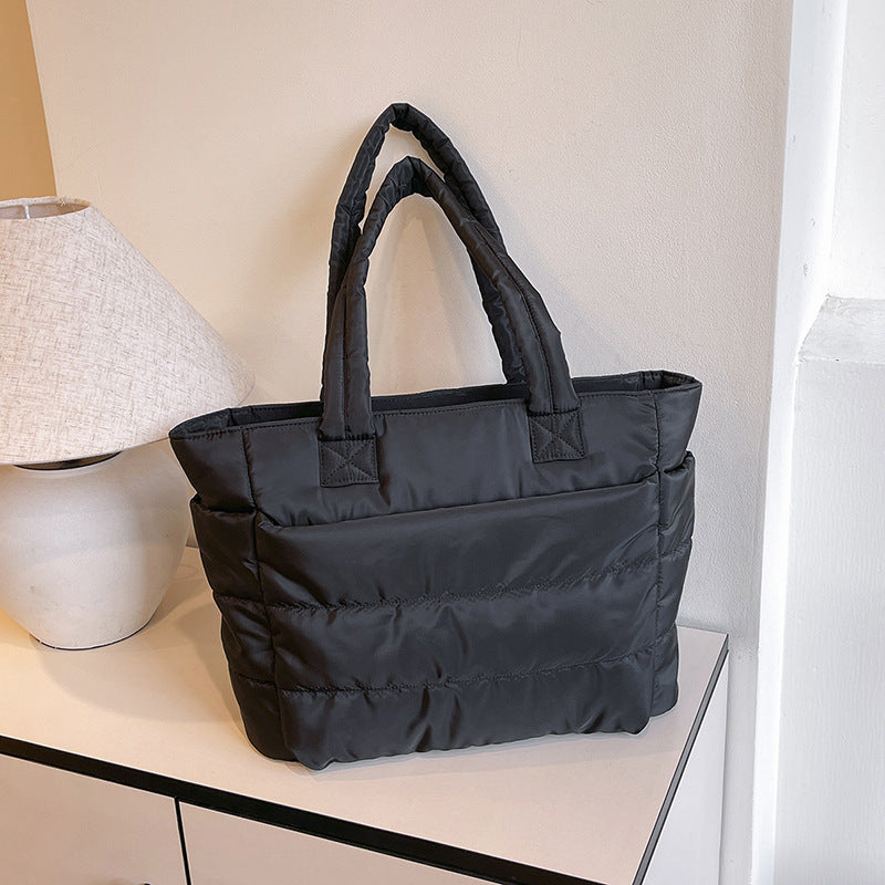 Minimalist tote bag for travel and laptop use available in black, grey, and pink colors