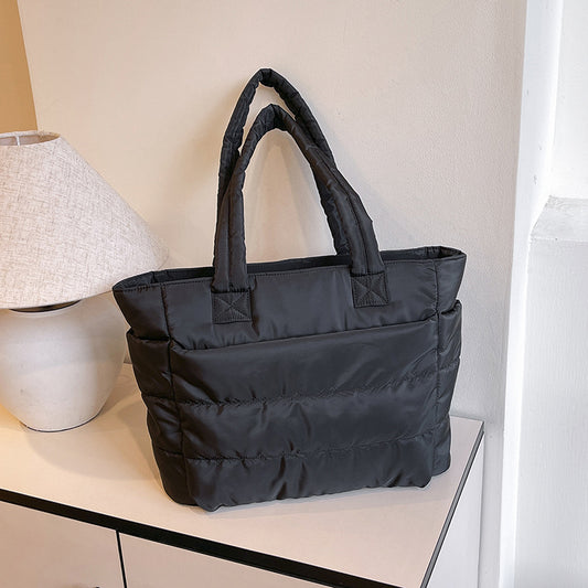 Minimalist tote bag for travel and laptop use available in black, grey, and pink colors