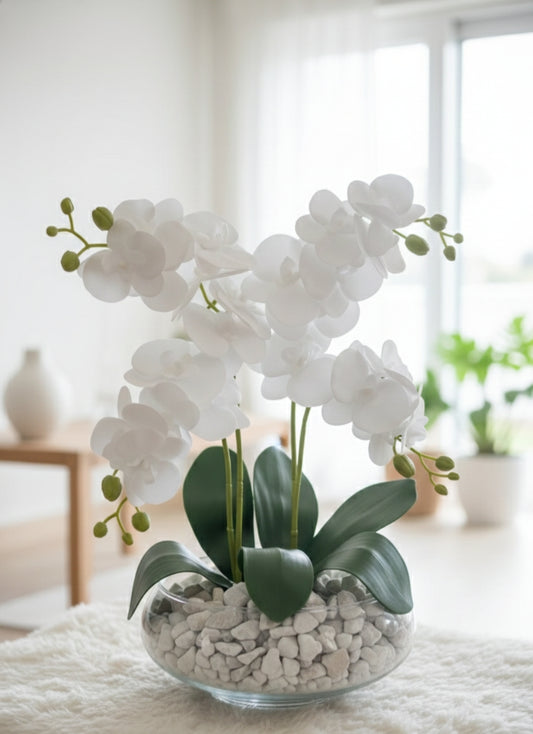 Glass vase with artificial orchid flowers for home or office décor.