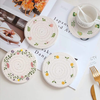 Set of two woven wooden place mats with decorative prints for pots and cups